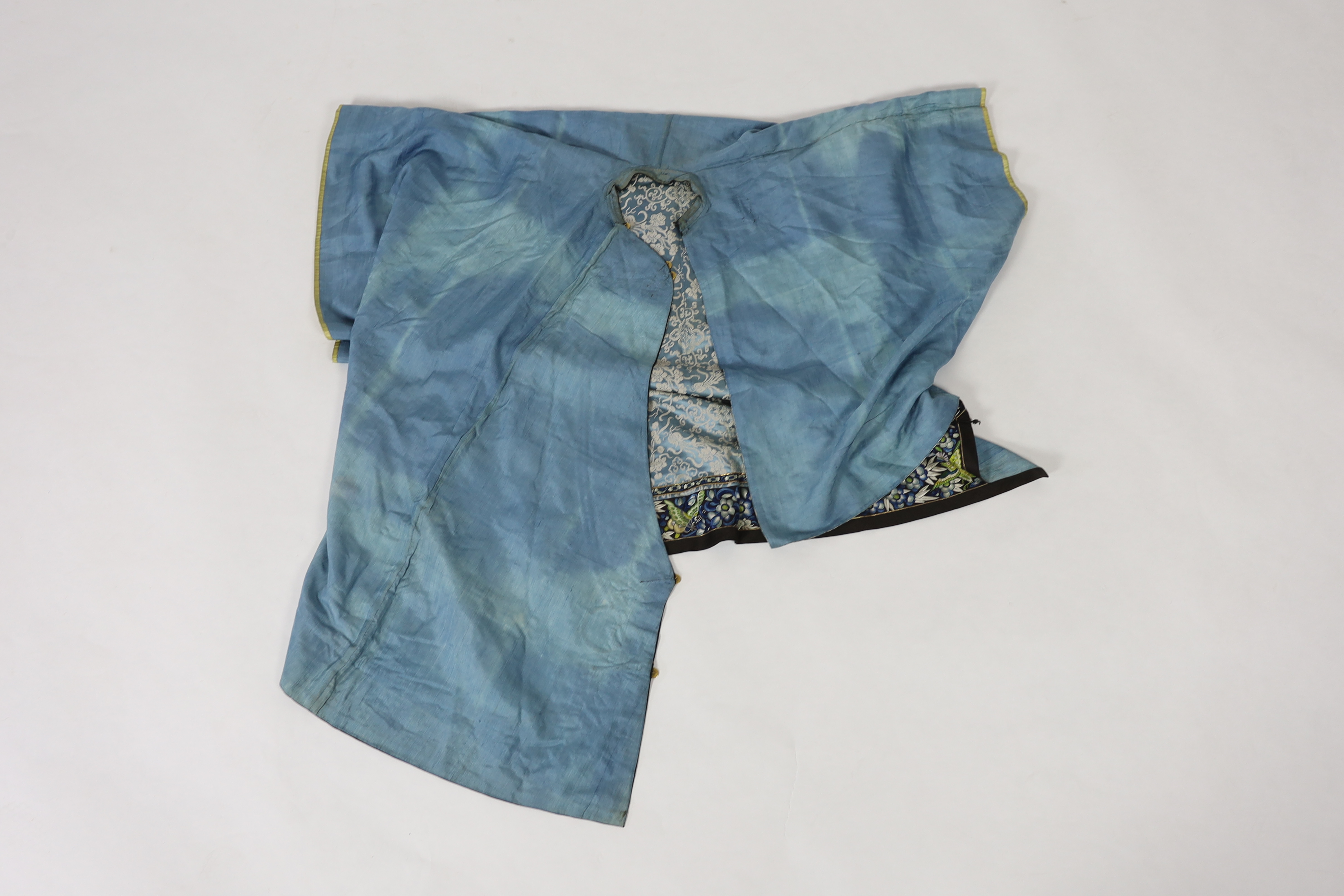 A late 19th / early 20th century silk damask robe, edged with highly ornate embroidered silk braiding, edged with fine gold and black borders, with yellow silk embroidered sleeve bands, the blue silk lining is faded in p